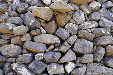 A wall built of lava stones. They have a dark gray color.