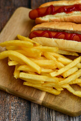 Tasty   Hot dogs and  deep fried french fries  on paper on wooden background