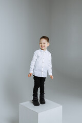 A boy in a light shirt on a wet background in the studio