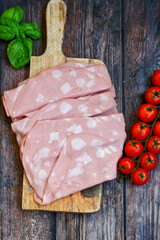 Slices Of  Traditional Italian antipasti mortadella Bolognese  on a wooden  cutting board. © Striker777