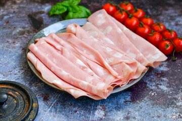 Slices Of  Traditional Italian antipasti mortadella Bolognese  on a wooden  cutting board.