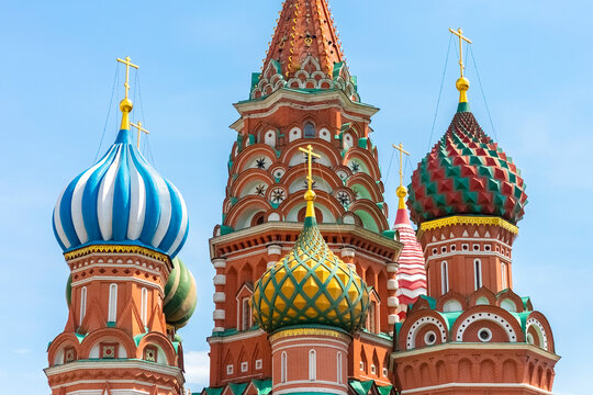 Colored domes of St. Basil's Cathedral against the blue sky. Close-up