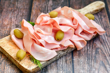 Slices Of  Traditional Italian antipasti mortadella Bolognese  on a wooden  cutting board © Striker777
