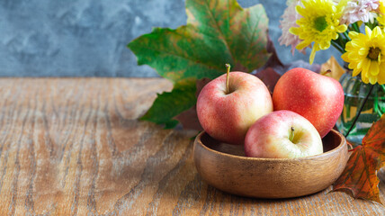 Autumn season or Thanksgiving holiday concept with apples, flowers and fall leaves, horizontal