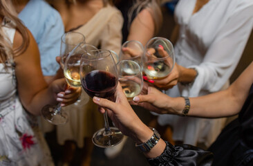 Celebration. People holding glasses of white wine making a toast.