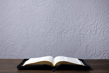 An open Bible on the table. Scripture
