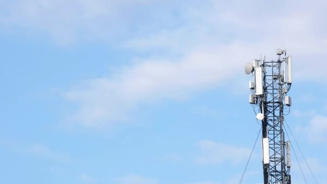 Cell site antenna on a blue sky and white clouds background. Place for text. Cell tower with mobile Telecommunications equipment. Cellular tower base station with electronic communications equipment 