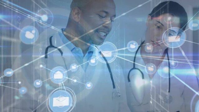 Animation of icons connected with lines over multiracial doctors discussing patient reports