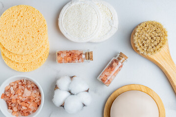 personal hygiene tools and cosmetics on white background. Face soap, brush with natural bristle. pink himalayan salt in a bowla, cotton and lufa reusable sponges for skin cleanser.