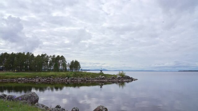 Siljan lake panorama timelapse. Clouds move fast over the beach of Tällberg village, municipality of Leksand, County of Dalarna. Large flat lake with picturesque islands and Scandinavian vegetation.