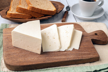 Artisanal fresh Canastra cheese with coffee and bread over wooden board
