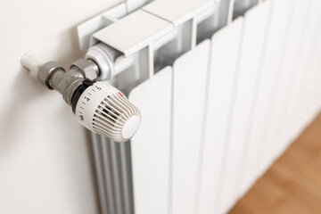 Heating radiator thermostat showing maximum temperature. Concept of waste and expenditure in heating