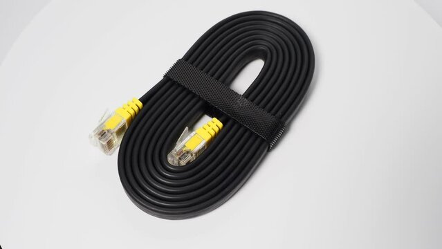 Flat black network cable on a white background. LAN cable.