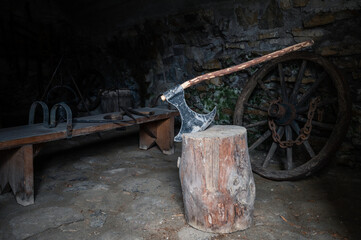 Executioner's ax stuck in a stump in the torture chamber - obrazy, fototapety, plakaty