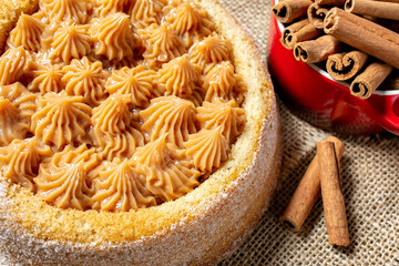 churros cake with dulce de leche topping with cinnamon sticks