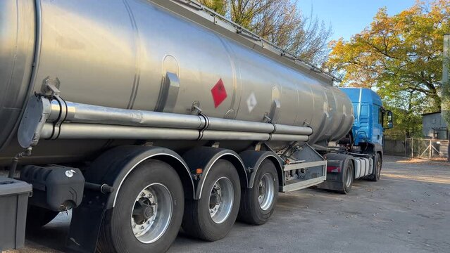 Gasoline truck stands in the parking lot of the oil depot, waiting for the tanks to be filled and the subsequent delivery of fuel to the gas station. Back view. Wide angle shot