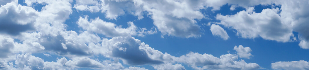 Beautiful blue sky with fluffy clouds in sunny day. Panoramic background.