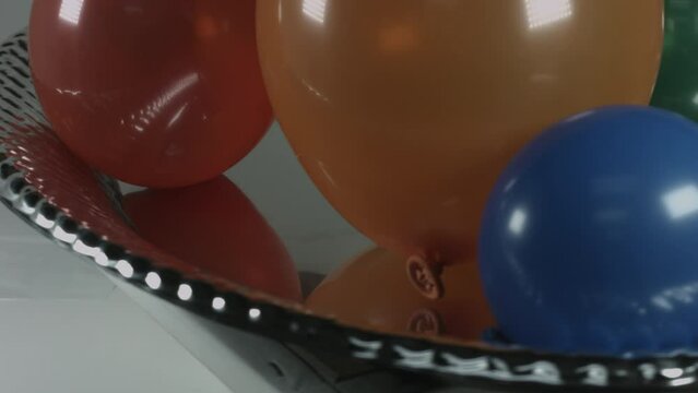 Multicolor Balloons Slowly Rotate on Metallic Platter 4K