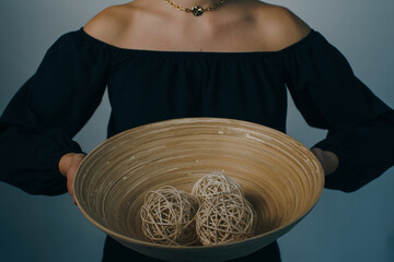 woman holding home decor. bamboo plate with branch balls. High quality photo