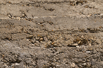 Close up of an old concrete wall. Texture for design. Rough, gray, shattered gravel.