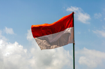 Fototapeta na wymiar An Indonesia Flag on old paper with blue sky background