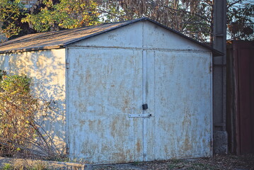one large gray closed garage in brown rust on the street