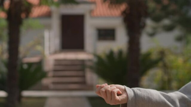 Close up Asian American female hand passing key male outdoors sunlight. Woman handing keys new house man customer. Buying dwelling. Selling home. Real-estate agent job. Handing over keys young couple.