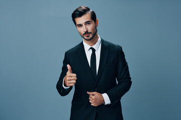 Man businessman smiles with teeth and thumbs up happy in business suit on blue background