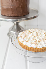 closeup to appetizing chocolate cake and pie with cream, ready-to-eat and decorated desserts, background