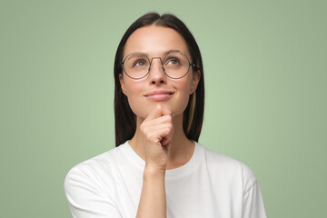 Closeup of woman dressed in white T-shirt, wearing spectacles and dreaming about something pleasant