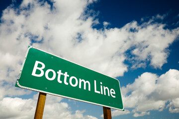 Bottom Line Green Road Sign Under Cloudy Blue Skies