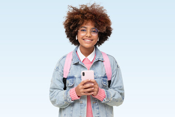African american smiling college girl with afro hair and glasses holding phone on green background