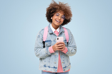Funny african american laughing school girl with afro hair, glasses and phone, looking at camera