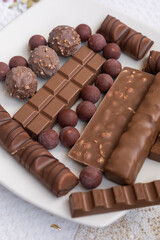 delicious decorative chocolates, candies on a plate, texture details in studio, food as a snack