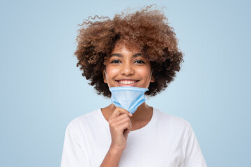 Portrait of smiling african american school girl with mask off after end of pandemic