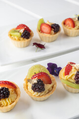 beautiful desserts decorated with fresh fruits and cream, wallpaper of delicious confectionery in studio, catering service, dishes