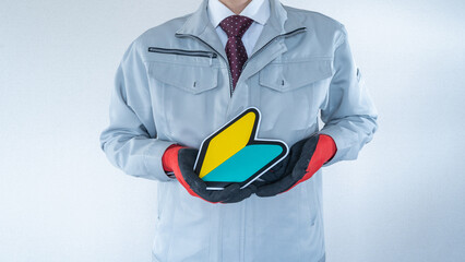 日本の初心者マークと作業服の男性