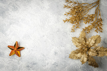 christmas background with golden leaves and branches and a star on white textured background