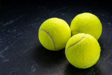 Tennis ball isolated on tennis racquet background, Yellow Tennis ball sports equipment on black background.