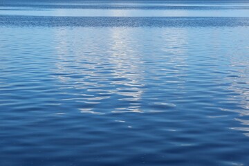 Light blue smooth water surface with shine and reflection on Florida river