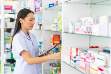 Medical pharmacy and healthcare providers concept. Attractive Asian woman pharmacist working on...