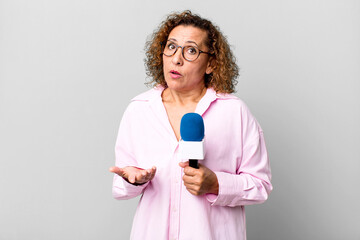 pretty middle age journalist woman with a micro. presenting concept