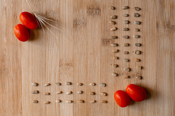 Red cherry tomatoes with sunflower seeds on wooden background