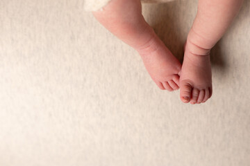 Newborn baby feet on an oatmeal background