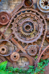 old rusty gear wheels with green plant