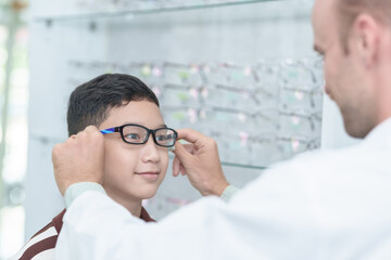 optometrist Glasses wearing glasses to a boy at a lens optical shop