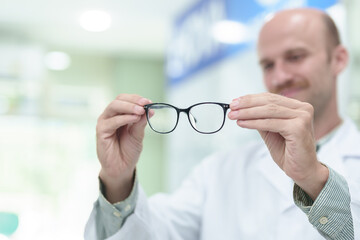 male ophthalmologist with eyeglasses in clinic, closeup. Space for text