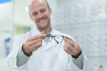 male ophthalmologist with eyeglasses in clinic, closeup. Space for text