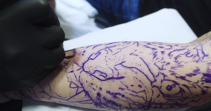 Close-up detail of the trace of a tiger design on a man's arm made by a professional tattoo artist.
