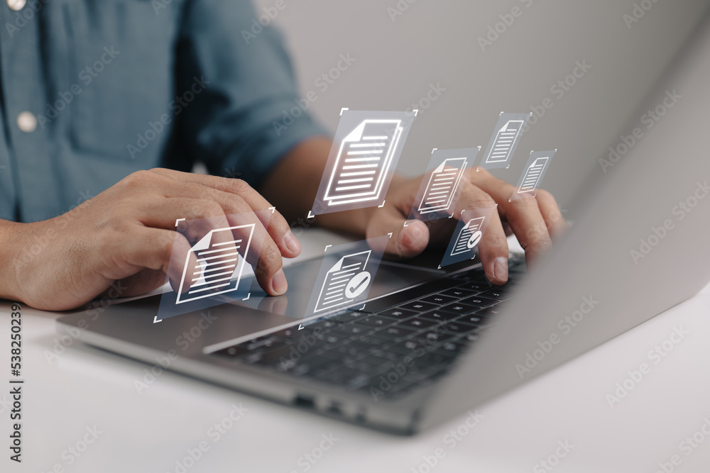 Poster businessman holding a laptop with a document management icon in it while utilizing the data system f